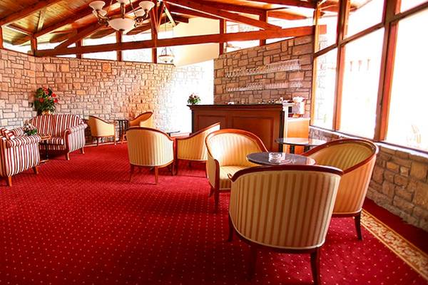 Der Loungebereich des Zora Hotels mit roten Teppichboden und vielen Sesseln.
