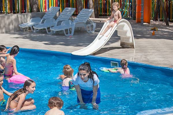 Kinder spielen und rutschen im Schwimmbad des Zora Hotels.