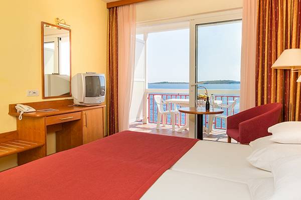 Ein Hotelzimmer des Zora Hotels mit Blick auf das Meer von einem Balkon.