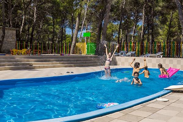 Kinder schwimmen im Pool des Zora Hotels im Freien.