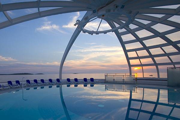 Der Pool des Zora Hotels bei Sonnenuntergang mit Blick auf das Meer