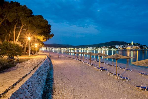 Zora Hotel Strand bei Nacht mit vielen Sonnenliegen und Sonnenschirmen