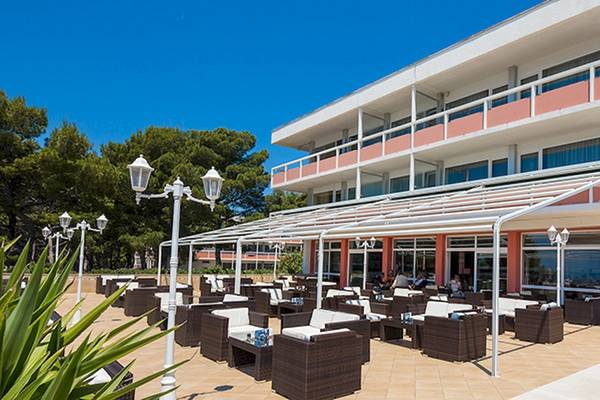 Zora Hotel Außenbereich mit Terrasse, Sitzgelegenheiten und Pavillon im Freien.
