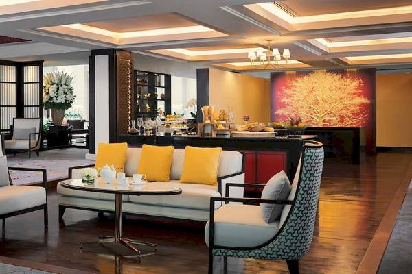 Lobby des Anantara Riverside Bangkok Resort mit Sofas, Tischen und Dekoration.