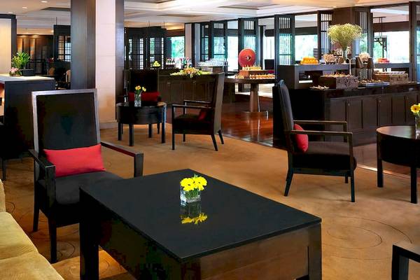 Lobby des Anantara Riverside Bangkok Resorts mit modernen Möbeln und Blumenarrangements.