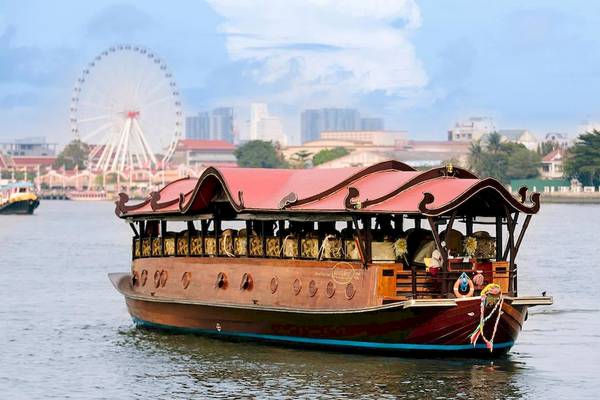 Bootstour vor dem Anantara Riverside Bangkok Resort mit Blick auf eine Stadt und ein Riesenrad