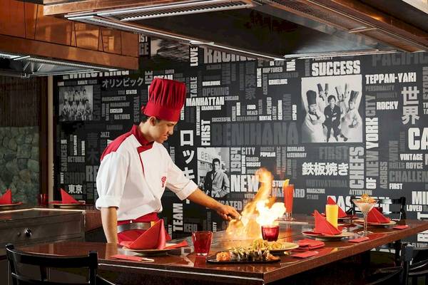 Koch im Anantara Riverside Bangkok Resort mit Flammen auf dem Tisch.