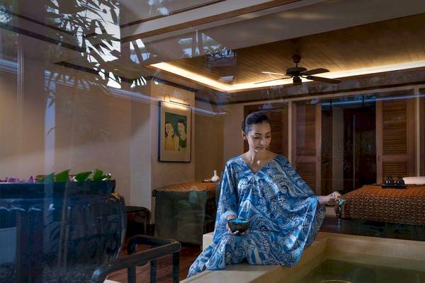 Frau im blauen Kleid am Rande eines Whirlpools im Spa-Bereich des Anantara Riverside Bangkok Resort
