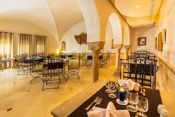 Innenansicht des Restaurants des Ulysse Djerba Thalasso & Spa Hotels mit Tisch, Stühlen und Kerzen.