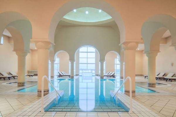 Innenpool des Ulysse Djerba Thalasso & Spa mit weißen Fliesen und blauem Wasser