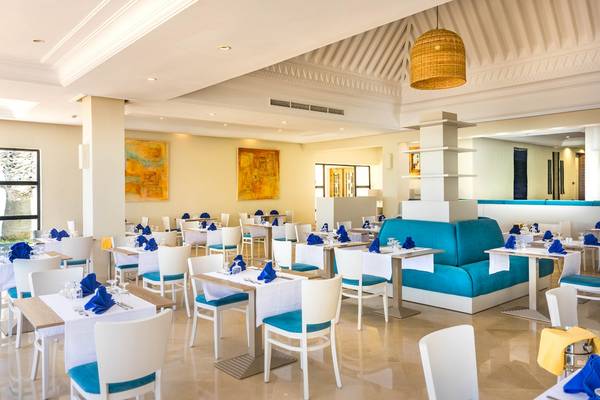 Innenansicht des Restaurants im Ulysse Djerba Thalasso & Spa Hotel mit blauen Sofas und weißen Tischen.