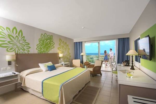 Blau Varadero Hotelzimmer mit Meerblick, Bett, Balkon, zwei Personen und Dekoration.