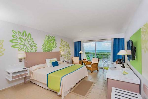 Innenansicht eines Hotelzimmers im Blau Varadero mit Bett, Schreibtisch und Blick auf den Ozean.