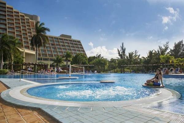 Ein Schwimmbad mit einer Frau auf einem Schwimmbrett vor dem Blau Varadero Hotel.