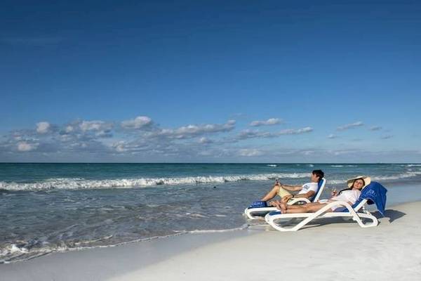 Ein Paar liegt auf Liegen am Strand des Blau Varadero Hotels.