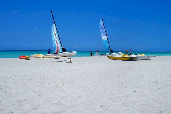 Zwei Segelboote am Strand des Blau Varadero Hotels mit blauem Himmel im Hintergrund.