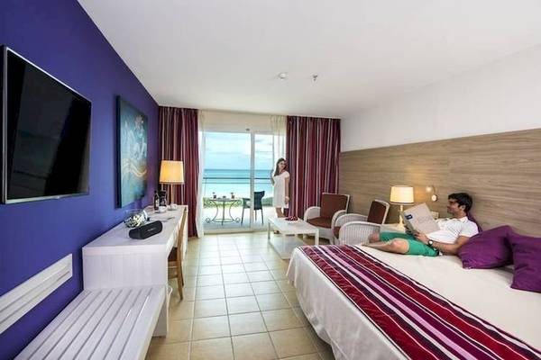 Mann im Hotelzimmer von Blau Varadero liest ein Buch, Blick auf den Ozean