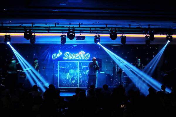 Live-Performance im Club Sueno mit einer Band auf der Bühne und Publikum.