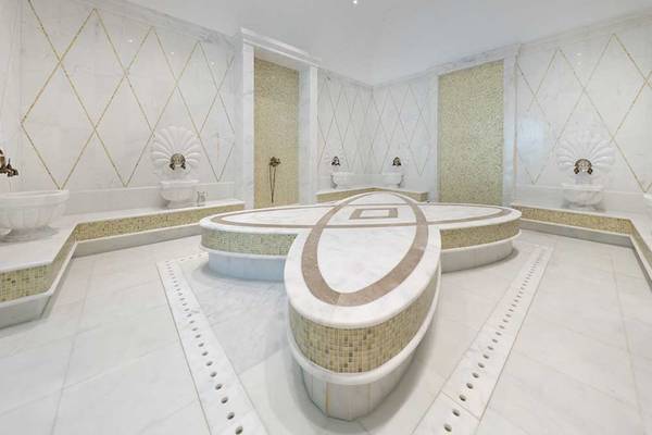 Spa-Bereich im Sueno Hotels Deluxe Belek mit weißen Marmorfliesen und goldenen Akzenten.