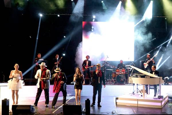 Bühnenshow im Sueno Hotels Deluxe Belek mit Musikern und Sängern unter Scheinwerfern.