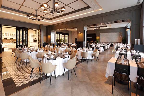 Innenansicht des Restaurants im Sueno Hotels Deluxe Belek mit gedeckten Tischen und Stühlen.