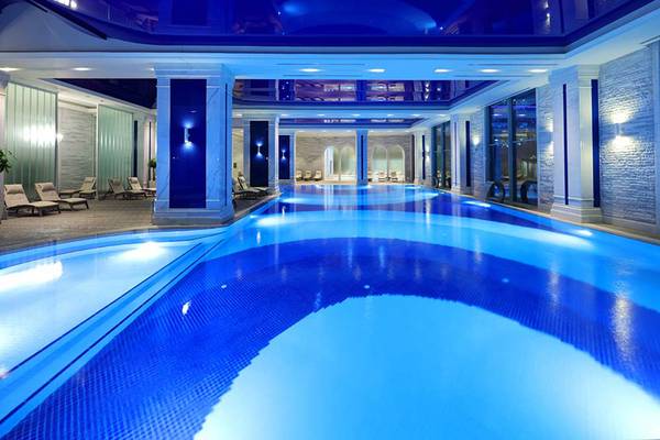 Innenpool des Sueno Hotels Deluxe Belek mit blauer Beleuchtung und Loungebereich