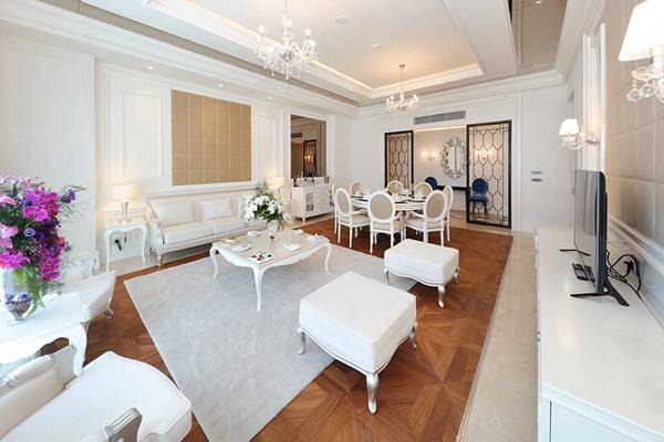 Luxuriöses Wohnzimmer im Sueno Hotels Deluxe Belek mit weißen Möbeln, Teppich und Tischdekoration.
