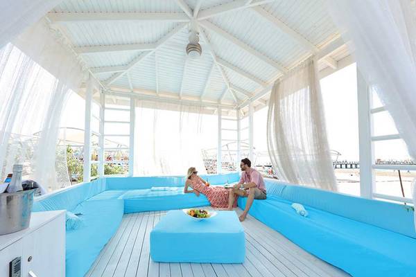 Paar auf blauen Sofas auf der Terrasse von Sueno Hotels Deluxe Belek