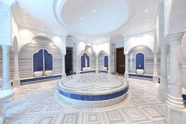 Innenansicht des Dampfbades im Sueno Hotels Deluxe Belek, mit weißen und blauen Fliesen und Marmorsäulen