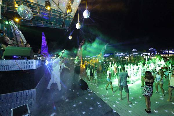 Nachtclub-Veranstaltung im Sueno Hotels Deluxe Belek mit Menschen, die tanzen und Discokugeln