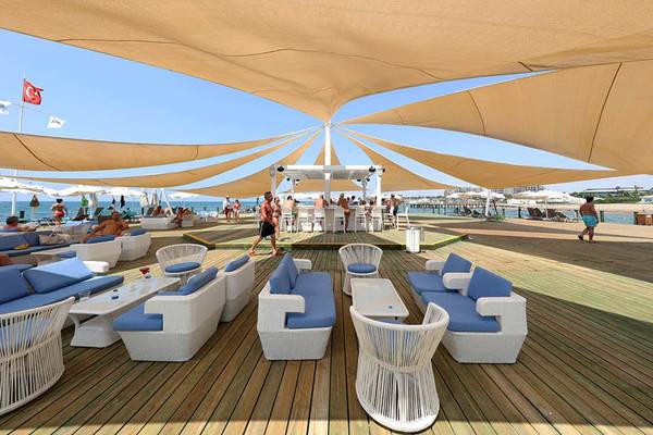 Terrasse des Sueno Hotels Deluxe Belek mit Sonnenschirmen und Loungemöbeln