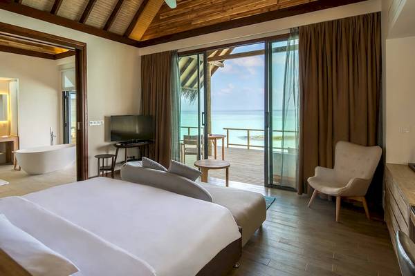 Innenansicht einer Hotelsuite im Fushifaru Maldives mit Blick auf das Meer.