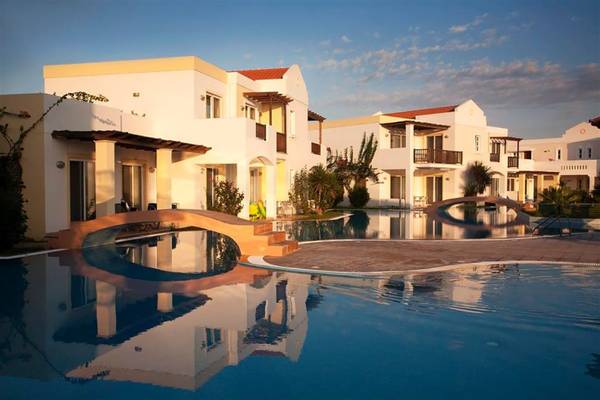 Außenbereich des Atlantica Marmari Beach Hotels mit Pool und architektonischen Elementen.