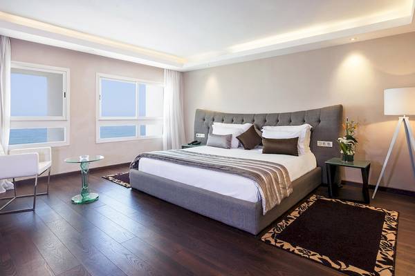 Schlafzimmer im Atlas Amadil Beach Hotel mit Meerblick, Bett, Nachttischen und Dekor.