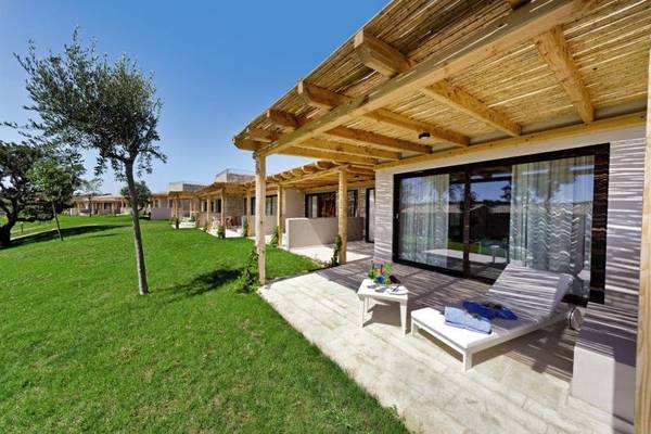 Außenbereich des Baglioni Resort Sardinia mit grüner Rasenfläche und modernen Gebäuden.