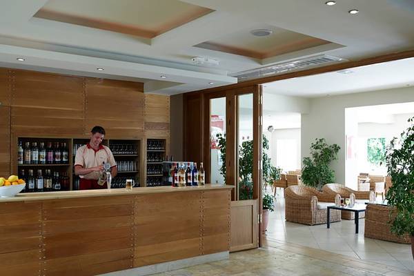 Barbereich im Atlantica Holiday Village Kos mit Barkeeper und gefüllten Flaschen