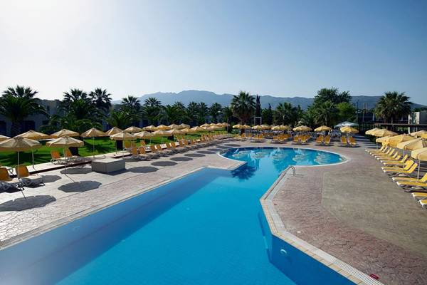Außenpoolbereich des Atlantica Holiday Village Kos mit Sonnenliegen und Sonnenschirmen
