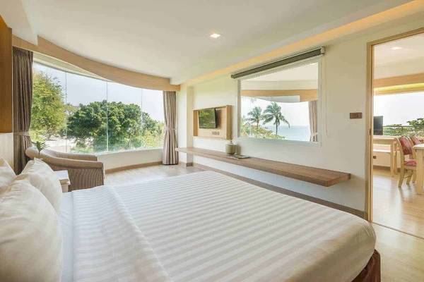 Schlafzimmer im Chaba Samui Resort mit Blick auf das Meer, großes Bett, Balkon und großer Fensterfront.