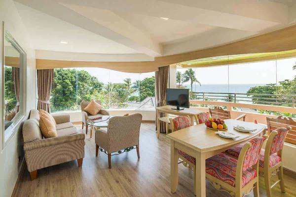 Wohnbereich des Chaba Samui Resorts mit Blick auf das Meer, große Fenster und moderne Einrichtung.