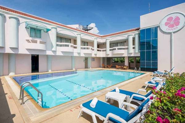 Außenpoolbereich des Chaba Samui Resorts mit Loungestühlen und Blumen.