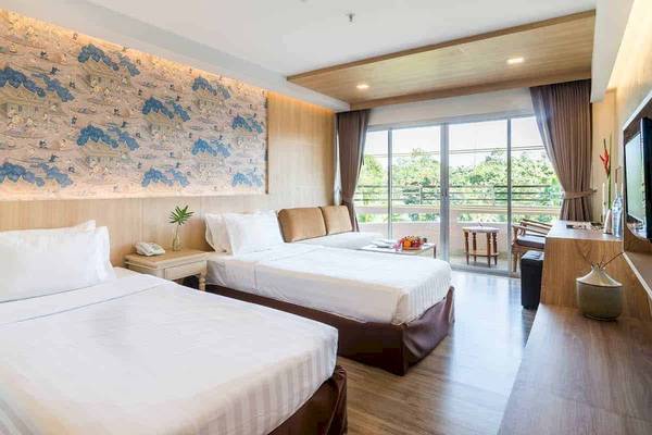 Doppelzimmer im Chaba Samui Resort mit zwei Betten, Balkon und Fernseher.