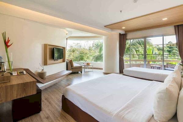 Hotelzimmer im Chaba Samui Resort mit zwei Betten, Fernseher und Blick auf die Natur.