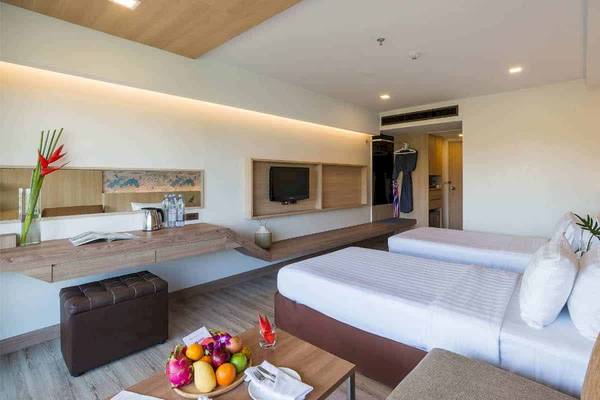 Doppelzimmer im Chaba Samui Resort mit zwei Betten, einem Schreibtisch und einem Fernseher.