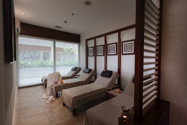 Massageraum im Barut B Suites Hotel mit drei Liegen, Fenstern und dekorativen Wandbildern.