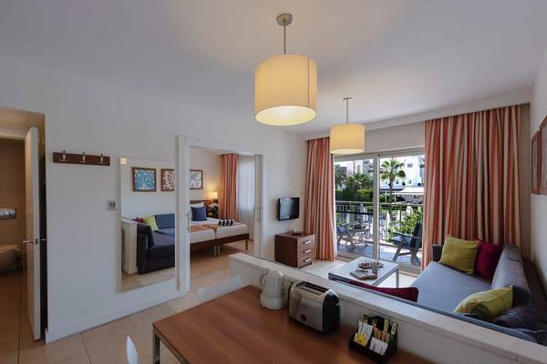 Innenansicht einer Suite im Barut B Suites Hotel mit Wohnzimmer, Schlafzimmer und Balkon.