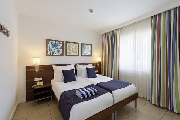 Doppelzimmer im Barut B Suites Hotel mit zwei Betten, Dekor und Fenstervorhängen.