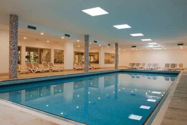 Innenpool des Barut B Suites Hotels mit Lounge-Liegestühlen und blauem Wasser