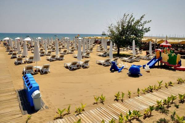 Strand mit vielen Sonnenliegen, Spielplatz und Bäumen, Barut B Suites Hotel