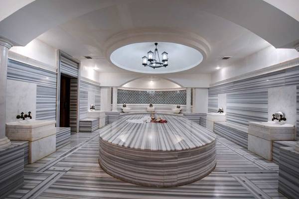 Innenansicht des Barut B Suites Hammam mit Marmorboden und zentraler Rundbank.