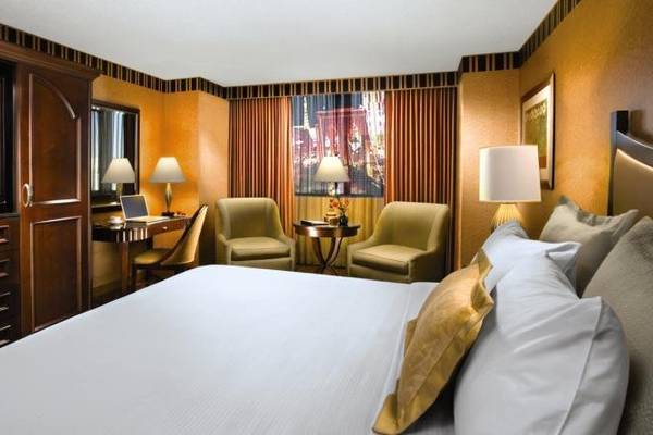 Hotelzimmer des New York-New York Hotel & Casino mit Bett, Schreibtisch, Stühlen und Fernseher.